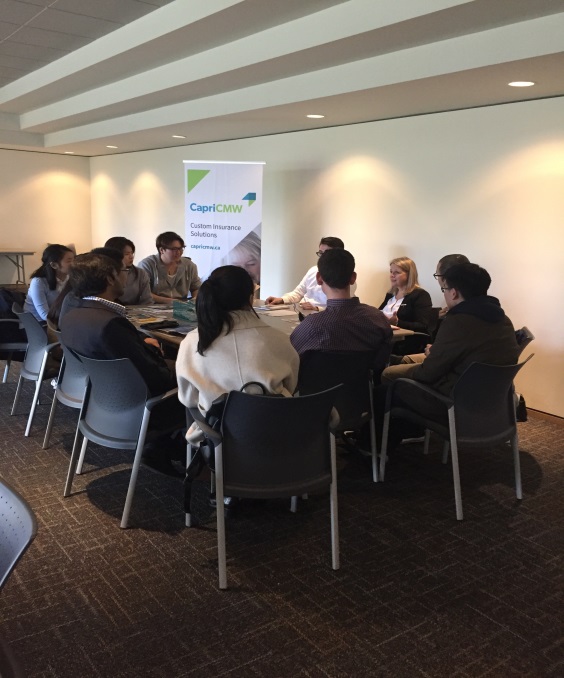 Group of students at an event sitting in a table with an employer